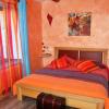 Chambre d’hôte pour 2 avec lit bois et cuir, cadre coloré aux saveurs épicées, lampes murales et malle de voyage dans un ensemble harmonieux et coloré avec vue sur le Château de Mostuejouls, Gorges du Tarn